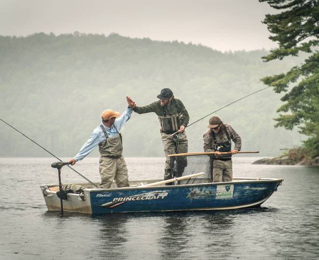 Trois pêcheurs dans une chaloupe.