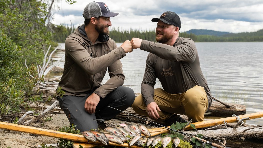 Deux hommes se félicitant de leurs poissons