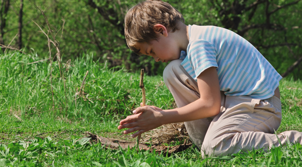 Un enfant qui essaie de faire du feu